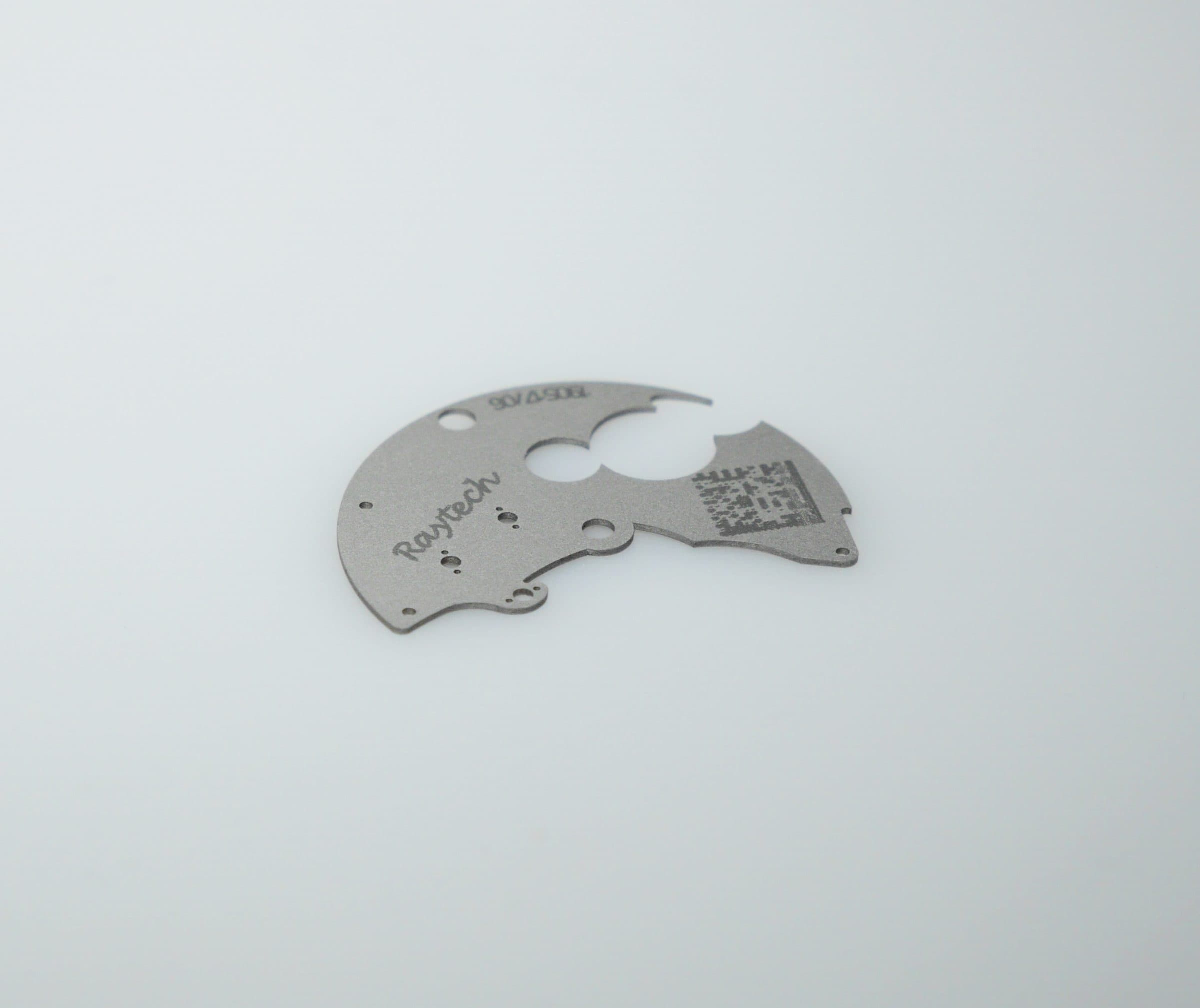 Thin laser-cut part with an engraved logo and QR code